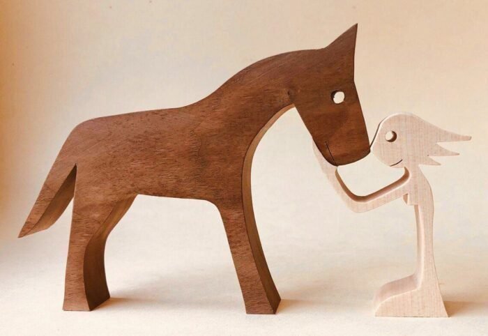 a woman a dark brown horse wood sculpture